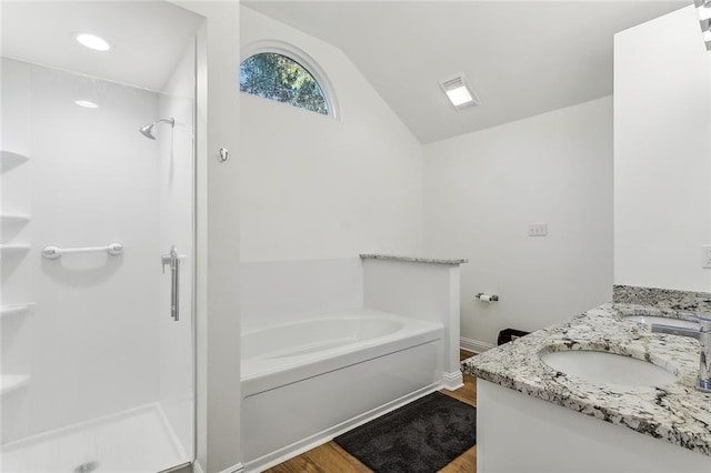 bathroom with vanity, wood-type flooring, lofted ceiling, and plus walk in shower