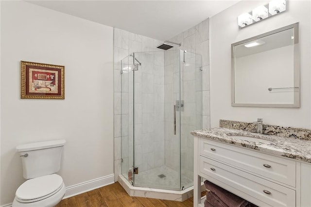 bathroom with vanity, toilet, wood-type flooring, and a shower with door