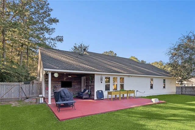 rear view of house with ceiling fan, a yard, and a patio