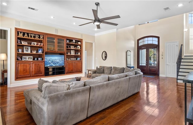 living room featuring ceiling fan, ornamental molding, and dark wood-type flooring