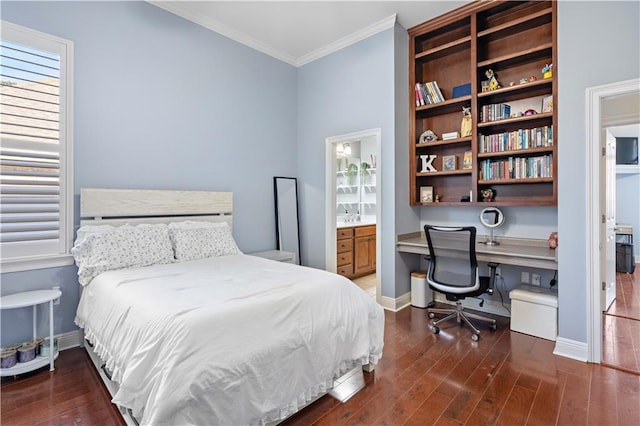 bedroom with connected bathroom, crown molding, built in desk, and dark hardwood / wood-style floors