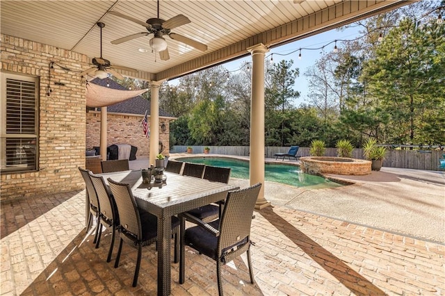 view of patio with ceiling fan and a pool with hot tub