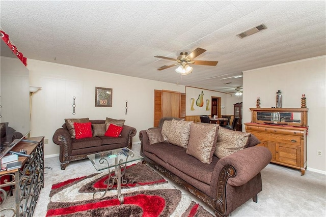 living room featuring light carpet, ceiling fan, and a textured ceiling