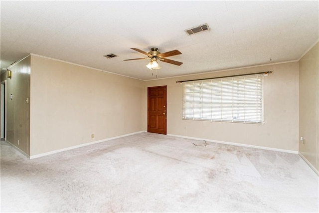 unfurnished room featuring ceiling fan, visible vents, and ornamental molding