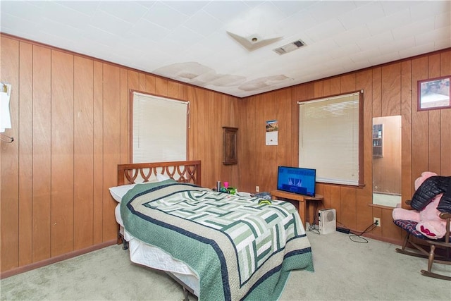 carpeted bedroom featuring wood walls