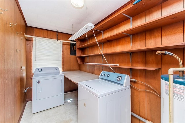 laundry room featuring water heater, laundry area, independent washer and dryer, and wood walls