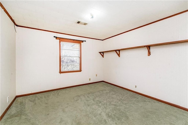 carpeted spare room featuring visible vents, baseboards, and ornamental molding