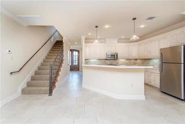 kitchen with decorative backsplash, stainless steel appliances, crown molding, light tile patterned floors, and hanging light fixtures