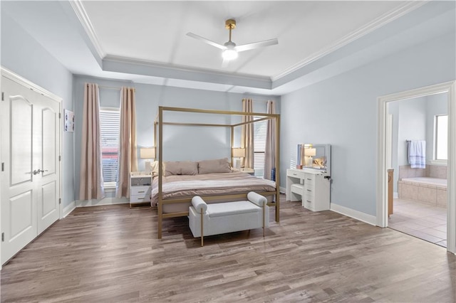 bedroom with a tray ceiling, ceiling fan, crown molding, and wood-type flooring