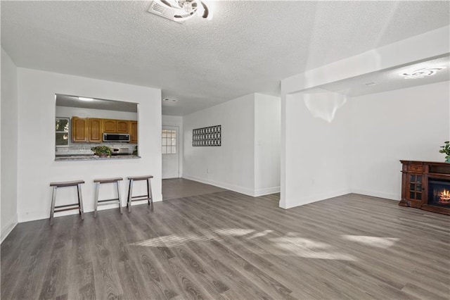 unfurnished living room with dark hardwood / wood-style floors and a textured ceiling