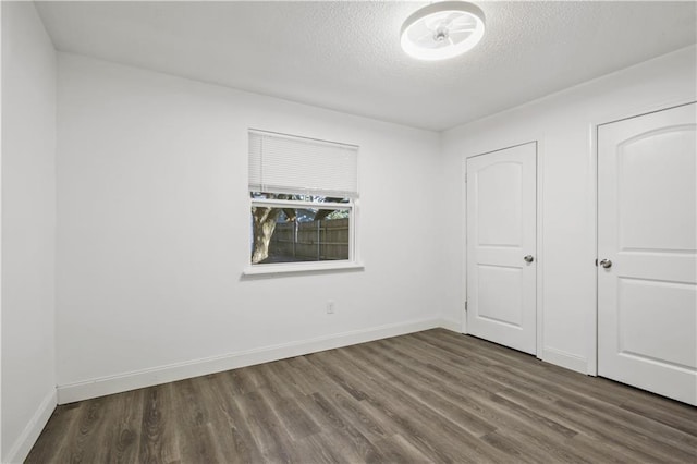 1492 W Hall Ave, Slidell, LA 70460 - unfurnished bedroom featuring wood finished floors, a textured ceiling, and baseboards