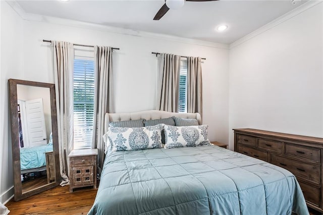 bedroom featuring multiple windows, ceiling fan, crown molding, and wood-type flooring