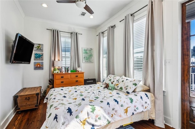 bedroom featuring ceiling fan, dark wood-type flooring, and multiple windows