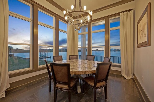 dining space with a water view and a chandelier