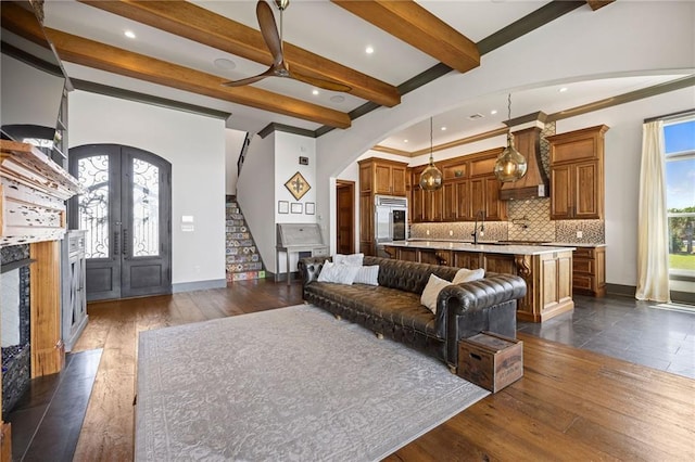 living room featuring dark wood-type flooring, french doors, sink, and beamed ceiling