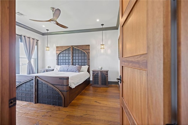 bedroom featuring crown molding, wood-type flooring, and ceiling fan