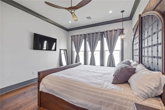 bedroom featuring dark wood-type flooring, ceiling fan, and crown molding