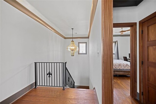 stairway with hardwood / wood-style flooring and ornamental molding