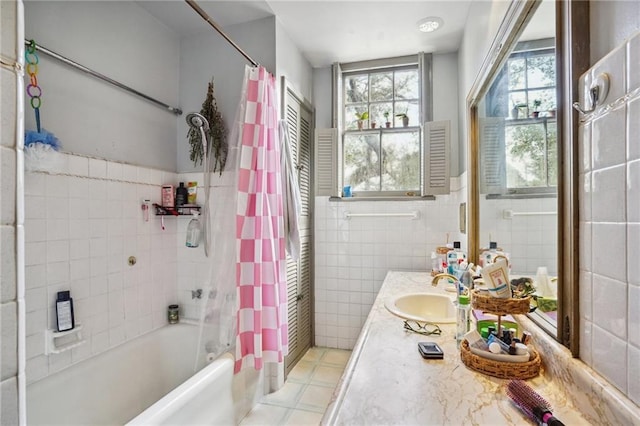 bathroom featuring vanity, shower / bathtub combination with curtain, and tile walls