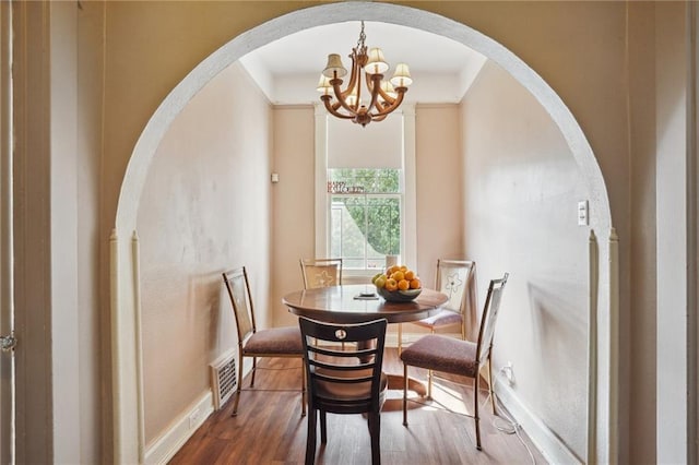 dining room featuring dark hardwood / wood-style flooring and a notable chandelier