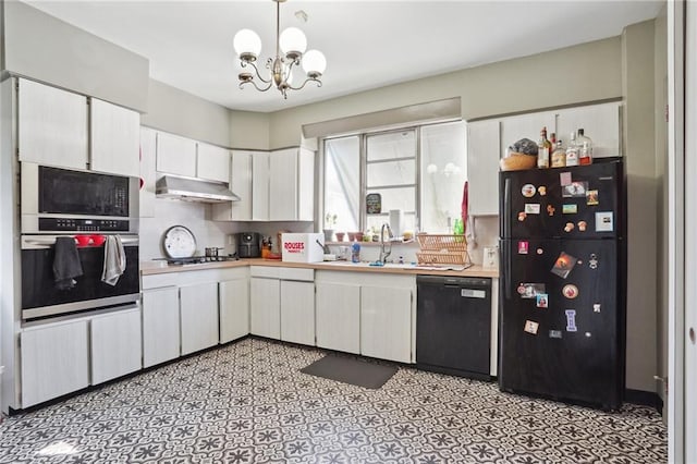 kitchen with white cabinets, appliances with stainless steel finishes, pendant lighting, and a notable chandelier