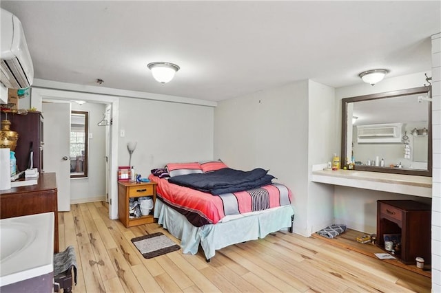 bedroom featuring light hardwood / wood-style floors and a wall mounted AC