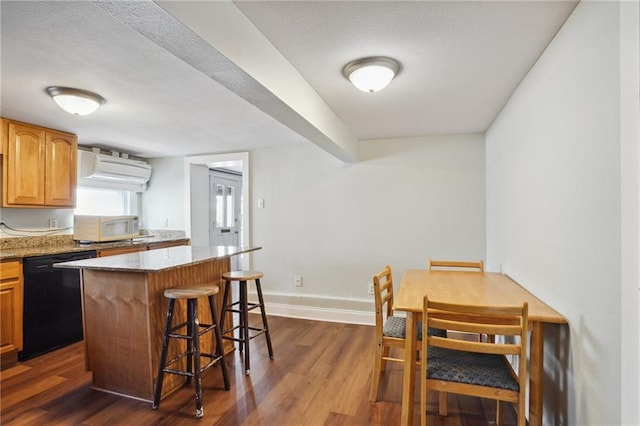 kitchen featuring dishwasher, a center island, dark wood-type flooring, a breakfast bar area, and a wall unit AC