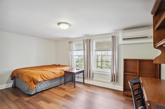 bedroom with dark hardwood / wood-style flooring and a wall mounted AC