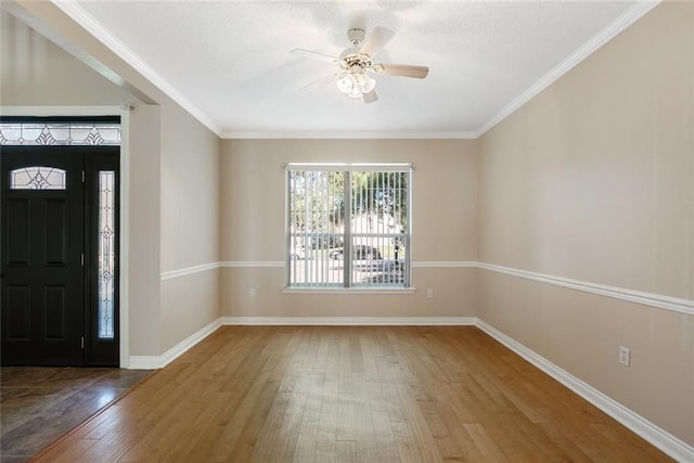 entrance foyer with ceiling fan, wood-type flooring, and crown molding