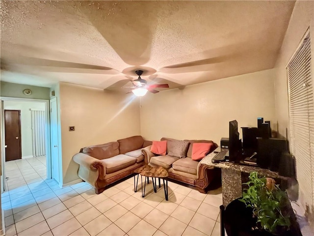 living room featuring ceiling fan, light tile patterned floors, and a textured ceiling