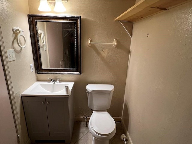 bathroom featuring tile patterned flooring, vanity, and toilet