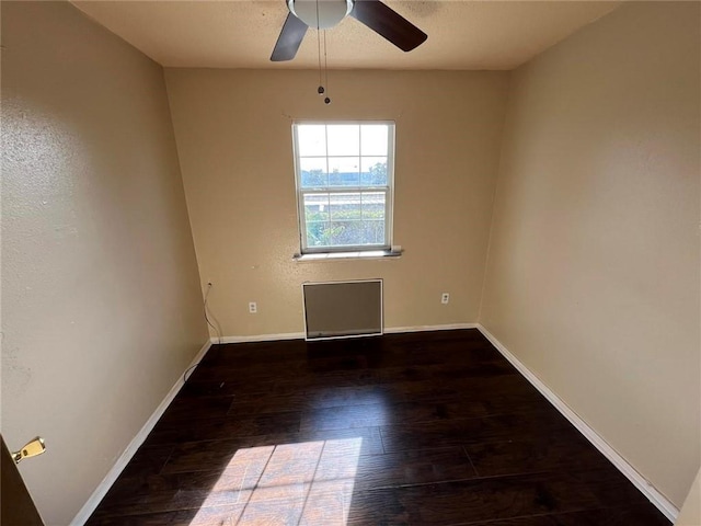 empty room featuring ceiling fan and dark wood-type flooring