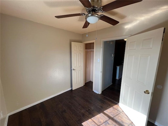 unfurnished bedroom featuring ceiling fan, dark hardwood / wood-style floors, and a closet