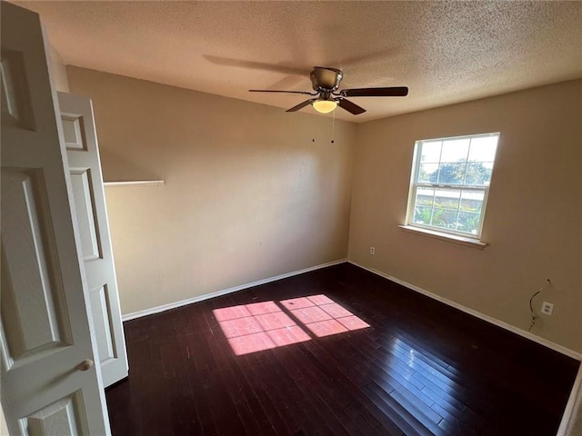 empty room featuring a textured ceiling, ceiling fan, and dark wood-type flooring