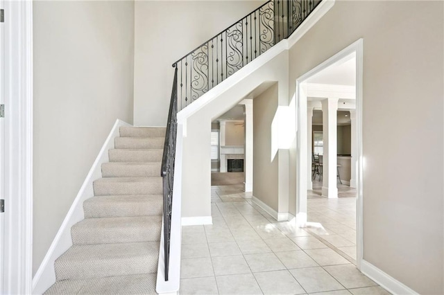 stairway featuring tile patterned flooring and a towering ceiling