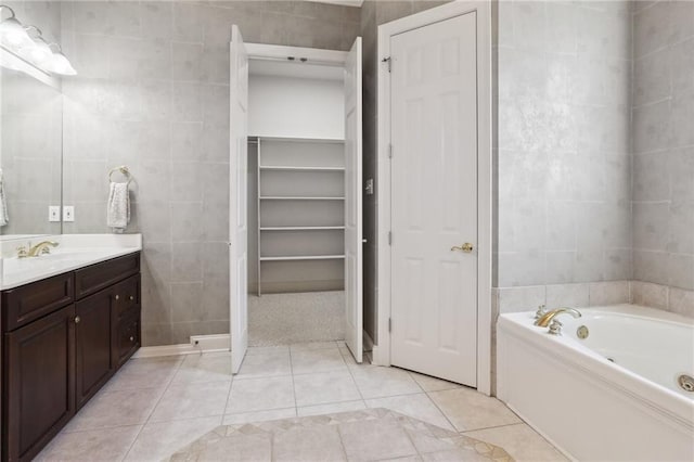 bathroom with tile patterned flooring, vanity, and tile walls