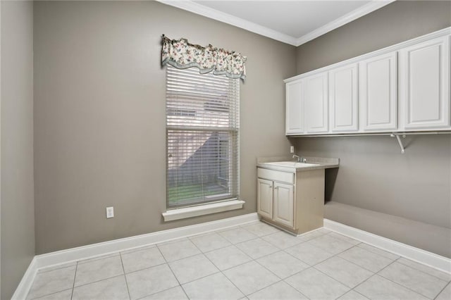 laundry room with crown molding, sink, and light tile patterned floors