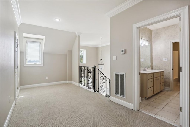 corridor featuring light colored carpet, a wealth of natural light, crown molding, and sink