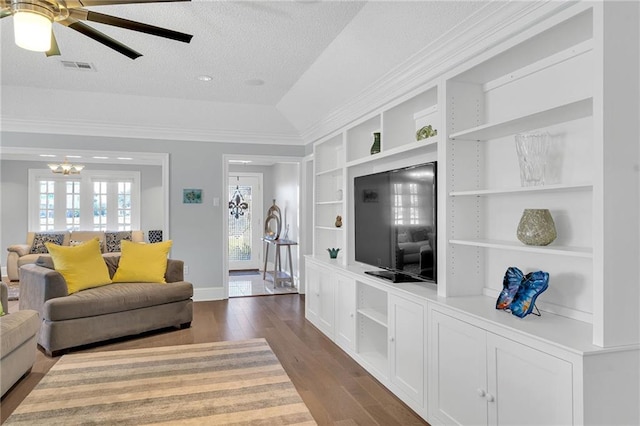 living room featuring built in features, dark hardwood / wood-style flooring, ceiling fan with notable chandelier, and a textured ceiling