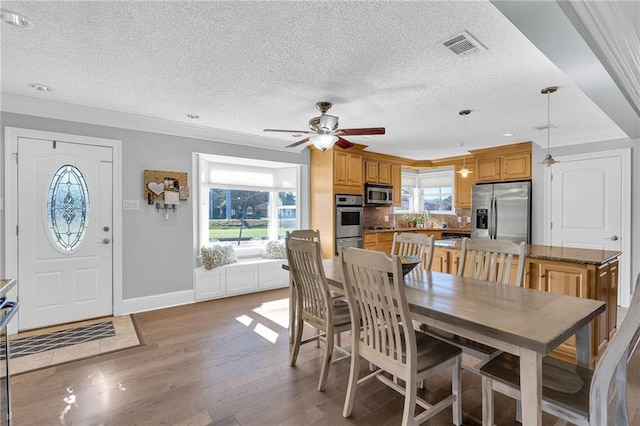 dining room with a textured ceiling, hardwood / wood-style flooring, ceiling fan, and a healthy amount of sunlight