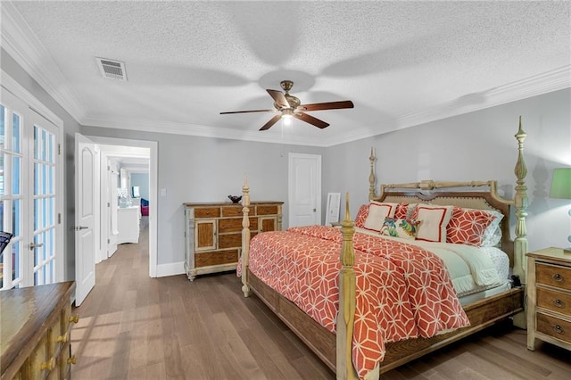 bedroom with ceiling fan, french doors, wood-type flooring, a textured ceiling, and ornamental molding