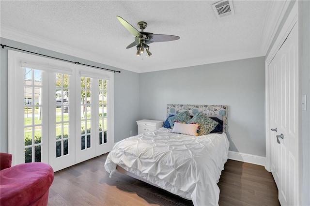 bedroom with dark wood-type flooring, ceiling fan, ornamental molding, a textured ceiling, and a closet