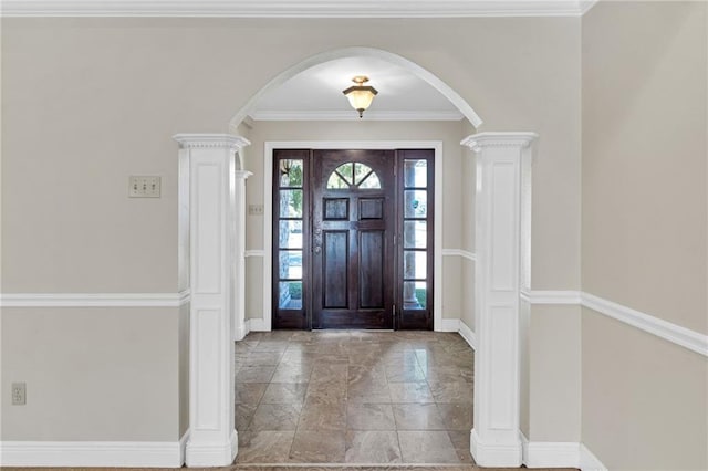 foyer entrance featuring ornate columns and crown molding