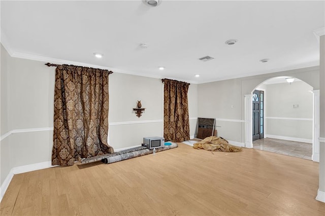 unfurnished living room featuring light hardwood / wood-style floors and crown molding