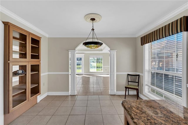 unfurnished dining area featuring decorative columns, light tile patterned floors, and ornamental molding