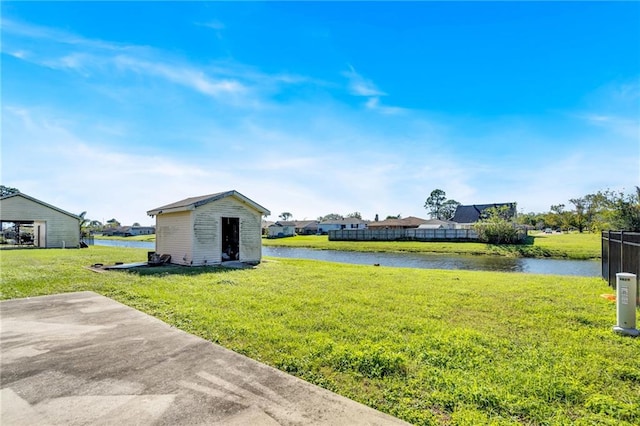 view of yard with a patio area, a water view, and a shed