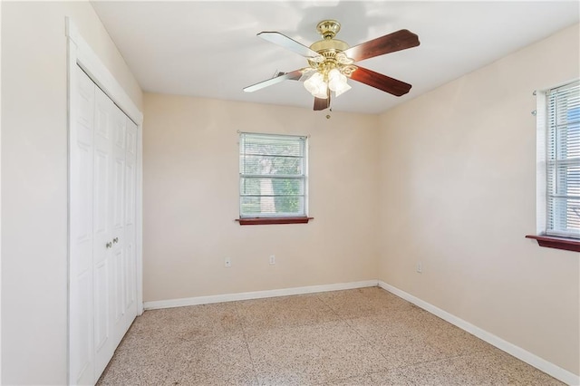 unfurnished bedroom with multiple windows, a closet, and ceiling fan