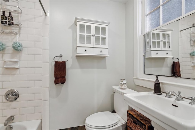 full bathroom with tiled shower / bath combo, toilet, and sink