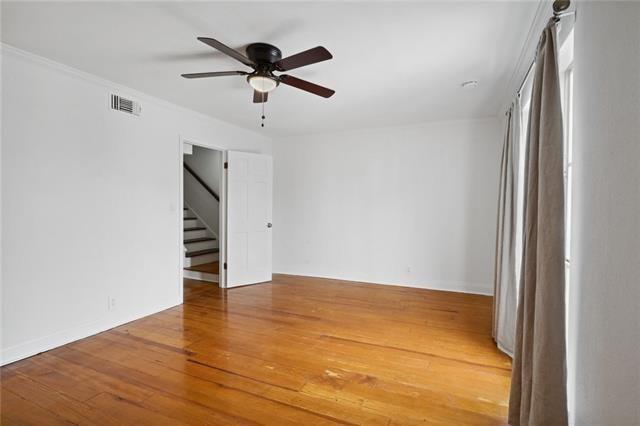 spare room with ceiling fan, crown molding, and wood-type flooring