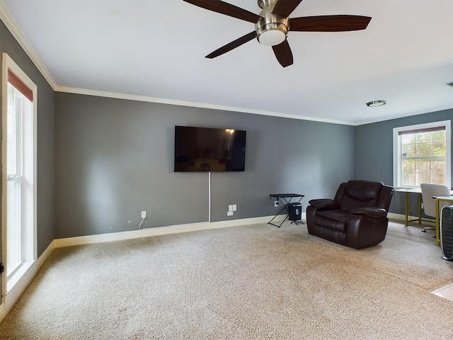 sitting room with carpet flooring, ceiling fan, and crown molding